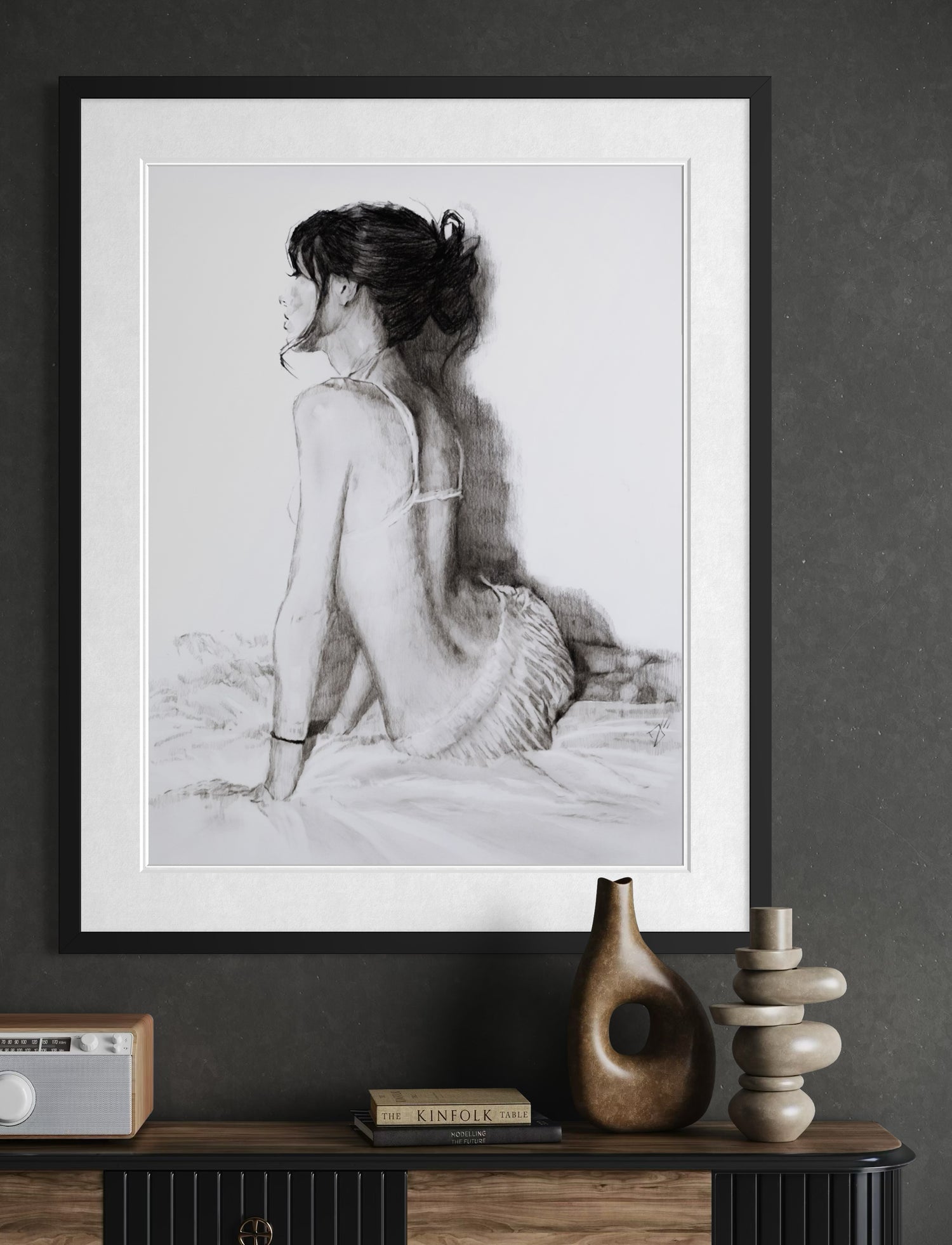 Hand-drawn charcoal figure drawing of a seated woman, framed original artwork.